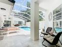 Covered pool area with ample seating and lounge chairs, providing a luxurious outdoor living space at 3211 Sunrise Walk, Kissimmee, FL 34747