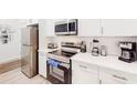 Modern kitchen with stainless appliances, white countertops, and cabinetry offering plenty of storage space at 359 Famagusta Dr, Davenport, FL 33896