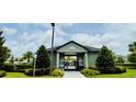 Community pool with a covered lounging area, fencing, and mature landscaping at 451 Lemongrass Rd, Minneola, FL 34715