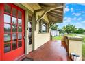 Inviting covered front porch with a striking red door and freshly painted accents at 1013 W 20Th St, Sanford, FL 32771