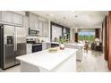 Modern kitchen featuring stainless steel appliances, gray cabinetry and a large island at 1023 Ladyfish Trl, St Cloud, FL 34771