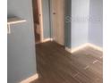 Bedroom featuring a stylish wood-look tile floor and soothing, light blue walls at 5084 Downing St # 2, Orlando, FL 32839