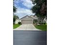 Single-story home with manicured landscaping, and a two-car garage at 4012 Capland Ave, Clermont, FL 34711