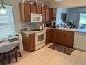 Functional kitchen featuring white appliances, ample cabinet space, and tile floors at 4012 Capland Ave, Clermont, FL 34711