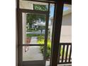Screened-in porch with view of lush landscaping and glimpse of neighboring house at 4012 Capland Ave, Clermont, FL 34711