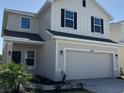 Exterior view of a two-story home with a two-car garage, modern color scheme and well-maintained landscaping at 4113 Sagefield Dr, Harmony, FL 34773