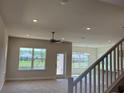 Bright, carpeted living room with a ceiling fan, large windows, and a view of the backyard and pond at 4113 Sagefield Dr, Harmony, FL 34773