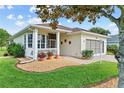 Inviting home exterior with well-kept lawn, brick walkway, and quaint screened-in porch area at 4738 St Andrews Arc, Leesburg, FL 34748