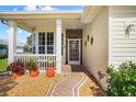 Welcoming front porch with decorative walkway, potted plants, and charming screened entrance at 4738 St Andrews Arc, Leesburg, FL 34748