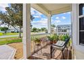 Covered front porch featuring comfortable seating and a pleasant view of the landscaped neighborhood at 4738 St Andrews Arc, Leesburg, FL 34748