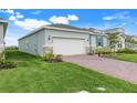 Side angle of the single-story home with a brick driveway, manicured lawn, and inviting curb appeal at 5724 Camilla St, St Cloud, FL 34771