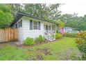 Charming white home with black shutters, a quaint porch, and a well-maintained lawn at 805 E 20Th St, Sanford, FL 32771