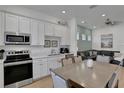 Modern kitchen with white cabinets, stainless steel appliances, quartz countertops, and an adjacent dining area at 8061 Lost Shaker Ln, Kissimmee, FL 34747