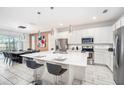 Modern kitchen with stainless steel appliances, white cabinets, a center island, and bar stool seating at 2613 Calistoga Ave, Kissimmee, FL 34741