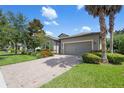 Beautifully landscaped home featuring a well-maintained lawn and brick driveway at 2008 Curia Rd, Winter Garden, FL 34787