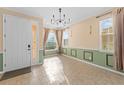 Bright entryway featuring tile flooring, a modern chandelier, and natural light streaming through multiple windows at 1011 Wood Cv, Kissimmee, FL 34743