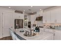 Modern kitchen with white cabinets, stainless steel appliances, and a large island with seating at 858 Arbor Green Trl, St Cloud, FL 34771