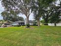 Lovely single-story home with mature trees, lush green lawn, and an attached two-car garage at 1405 Ridgegreen N Loop, Lakeland, FL 33809