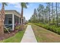 A community sidewalk with mature landscaping and green spaces for a pedestrian-friendly experience at 311 Pop Top Ln, Daytona Beach, FL 32124