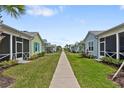 Landscaped street view of cottage-style homes, manicured lawns, and sidewalks that invite a walk at 311 Pop Top Ln, Daytona Beach, FL 32124