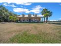 Charming home with a metal roof, dormers, and a wide front porch, surrounded by a green lawn and mature trees at 2198 W Highway 329, Citra, FL 32113