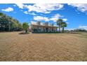 Charming home with a metal roof, dormers, and a wide front porch, surrounded by a green lawn and mature trees at 2198 W Highway 329, Citra, FL 32113