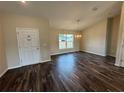 Living room featuring dark wood vinyl flooring, natural light and a modern chandelier at 6711 Sw 64Th Ave, Ocala, FL 34476