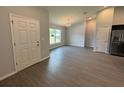 Open-concept living room with gray floors and modern chandelier at 7051 Sw 64Th Ter, Ocala, FL 34476