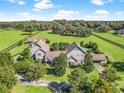 An aerial view of a luxurious estate featuring sprawling green lawns and a meticulously designed circular driveway at 10621 Sw 11Th Ter, Ocala, FL 34476