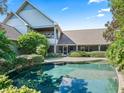 Backyard features a refreshing pool, surrounded by manicured gardens and ample space for outdoor seating at 10621 Sw 11Th Ter, Ocala, FL 34476