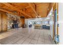 Spacious living room with stone fireplace and vaulted wood ceiling at 22345 Ne 108Th Avenue Rd, Fort Mc Coy, FL 32134
