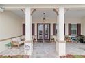 Inviting covered front porch with beautiful stone floors, decorative columns and comfortable seating at 8160 Sw 92Nd Cir, Ocala, FL 34481