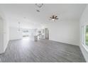 Open-concept living room with white walls, gray flooring, and modern ceiling fan and lighting at 13026 Ne 6 Pl, Silver Springs, FL 34488