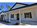 Inviting front porch with black columns and stylish lanterns at Tbd W C 466 # Lot 1, Oxford, FL 34484