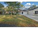 Charming single-story home featuring a well-manicured lawn, attached garage and neutral color scheme at 8655 Sw 98Th Street Rd # G, Ocala, FL 34481