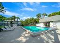 Inviting community pool with lounge chairs and tropical landscaping at 567 Midway Trak # H102, Ocala, FL 34472
