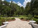 Brick pathway meanders through a scenic landscape with oak trees at 3440 Sw 66Th St, Ocala, FL 34476