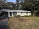 Ranch-style house with a well-maintained yard and a tree at 1105 Ne 45 Pl, Ocala, FL 34479