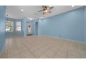 Bright living room features neutral tile flooring, blue accent wall, and a front door at 8655 Sw 86Th Cir, Ocala, FL 34481