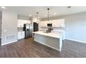 Modern kitchen features stainless steel appliances, white cabinetry, and a center island at 4544 Sw 156Th Pl, Ocala, FL 34473