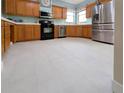 Traditional kitchen featuring wood cabinets, black appliances, stainless steel refrigerator, and light countertops at 4348 Sw Deepwater Ct, Dunnellon, Fl, FL 34431