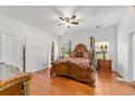 Luxurious main bedroom with hardwood floors, ceiling fan, and ornate four-poster bed at 14550 Sw 61St Ct, Ocala, FL 34473