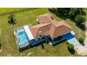 Stunning aerial view of home with screened pool and ample lawn space, nestled in a lush green landscape at 174 Juniper Trl, Ocala, FL 34480