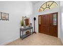 Inviting entryway with beautiful wood door, transom window, and decorative console table, creating a warm welcome at 2818 Se 24Th Ave, Ocala, FL 34471