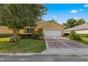 House exterior with a two-car garage and lush landscaping at 9823 Sw 95Th Loop, Ocala, FL 34481