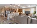 Open concept living area showcasing kitchen with bar seating, stainless appliances, and a comfortable seating area at 9994 Sw 96Th St, Ocala, FL 34481