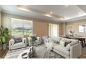 Bright, open living room with stylish furnishings, large windows, and access to the outdoor area at 9994 Sw 96Th St, Ocala, FL 34481