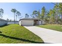 Single-Gathering house showcasing a well-maintained lawn, concrete driveway, and craftsman-style elements at 13374 Sw 63Rd Ter, Ocala, FL 34473
