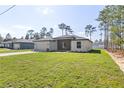 Exterior view of a single-story home with a two-car garage and a well-manicured lawn at 13374 Sw 63Rd Ter, Ocala, FL 34473