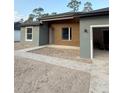 Modern home showcasing a clean design with an open garage and walkway leading to the entrance at 13392 Sw 63Rd Ter, Ocala, FL 34473